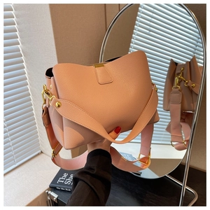 Pink lychee texture leather bucket bag with wide fabric strap and golden hardware