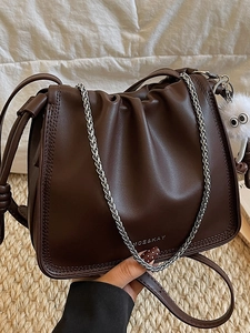 Sac à bandoulière marron foncé plissé avec chaîne et pompon pelucheux en décor intérieur