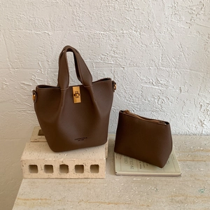 Détail de l'ensemble sac seau en cuir litchi marron foncé avec fermoir doré et pochette