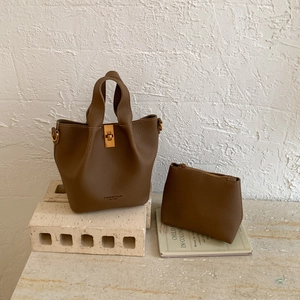 Détail du sac seau marron caramel avec pochette intérieure sur un décor artistique