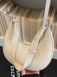Chic off-white half-moon hobo bag with adjustable wide strap and silver zipper closure