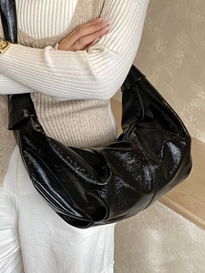 Glossy black croissant shoulder bag with pleated leather texture in half-moon shape