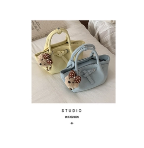 Close-up of pastel bucket bags with bow details and cute plush bear pendants