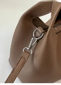 Detalle de los herrajes plateados brillantes y el cuero de grano litchi en el bolso marrón