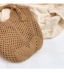 Gros plan du sac cabas au crochet beige avec texture tricotée et pompon décoratif
