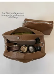 Vista superior de bolso bombonera de cuero marrón que muestra interior amplio y estuche