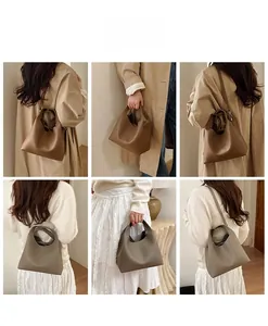 Detalle de bolsos tipo cubo en cuero marrón y gris con textura de grano de lichi fina
