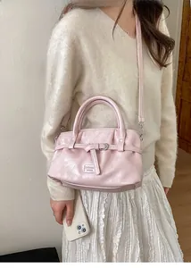 Close-up of pink pleated bucket bag with metal buckle and fashion logo detail