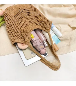 Vue détaillée d'un sac cabas tissé kaki montrant l'intérieur spacieux et les franges