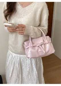 Detailed view of a pink handbag with bow buckle and Fashion & Bags brand lettering