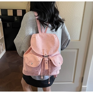 Sac à dos rose à étoiles montrant les doubles poches avant et la fermeture à cordon
