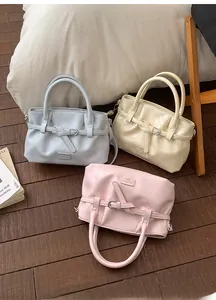 Detailed view of light blue, beige, and pink pleated leather handbags on a soft bed