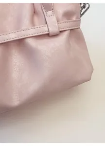 Detail of pink textured leather handbag with fine stitching and silver hardware