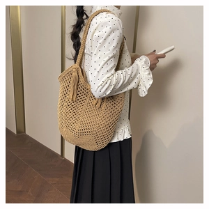 Détail d'un sac cabas en crochet fait main avec motif ajouré et pampilles latérales