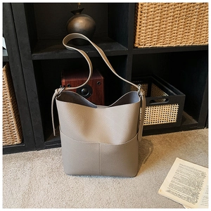 Detail view of the taupe lychee texture leather bucket bag with fine stitching