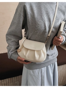 Détail du sac bandoulière crème avec bordure plissée et texte logo Fashion & Bags