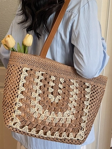 Handwoven straw tote bag with geometric wave patterns and brown leather straps for beach