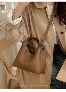 Bolso tipo cubo de cuero granulado marrón con gabardina beige en un ambiente retro