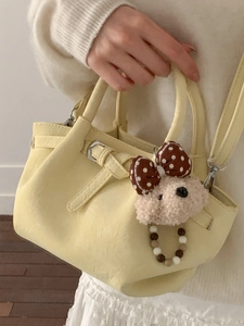 Fashionable creamy yellow bucket bag with cute plush bear charm and beaded strap