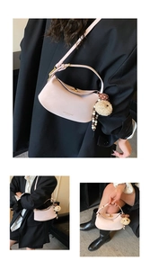 Detail of pink crescent bag featuring pebble leather texture and cute sheep pendant