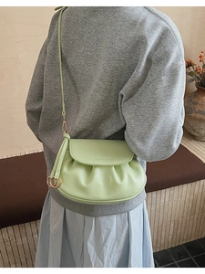 Détail du sac bandoulière vert clair avec plis nuage et breloque anneau doré élégante