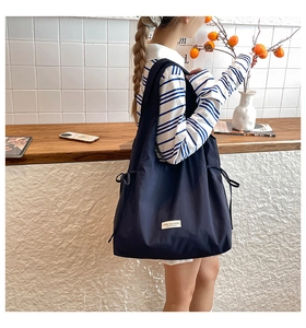 Detail der tiefblauen Nylon-Einkaufstasche mit Kordelzug und stilvollem Textiletikett
