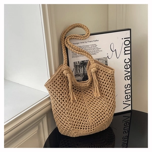 Détail du sac cabas beige tissé à la main avec motif en maille ajourée et décor de franges