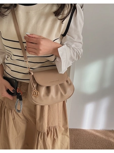 Détail du sac à bandoulière en cuir kaki avec design plissé et boucle dorée anneau