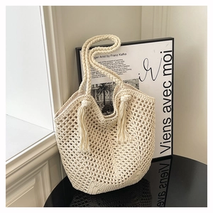 Détail de la texture en maille du sac cabas beige avec des finitions à franges chic