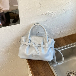 Detail of light blue pleated cloud bag with silver buckle and adjustable shoulder strap