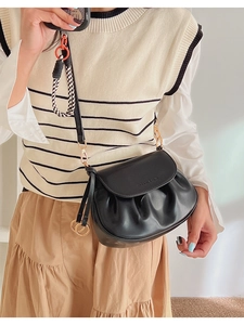 Détail de la sacoche plissée en cuir PU noir avec rabat et anneau doré poli