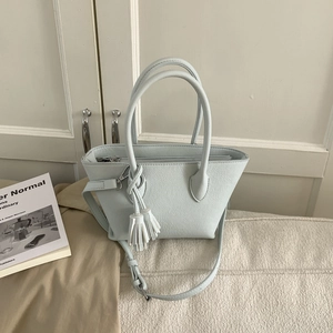Vue détaillée du sac seau bleu menthe avec texture cuir litchi et gland décoratif