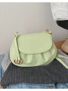 Détail du sac bandoulière vert menthe en cuir PU avec anneaux dorés sur vêtements décontractés