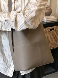 Minimalist taupe lychee leather bucket bag with large capacity for daily commuting
