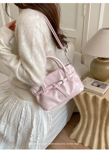 Close-up of pink pleated leather bucket bag with top handles and adjustable strap