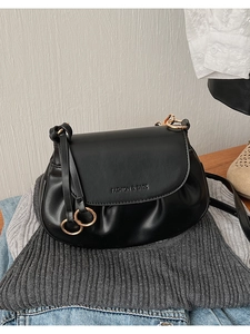 Détail d'un sac besace noir mat avec anneaux dorés entrelacés et embossage Fashion & Bags