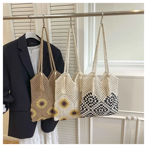 Gros plan détaillé de sacs cabas au crochet faits main avec motifs floraux et géométriques