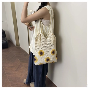 Détail d'un sac cabas au crochet avec motifs tournesols et large bandoulière tressée
