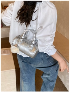 Silver metallic cylinder bag with pleated texture and wide printed shoulder strap