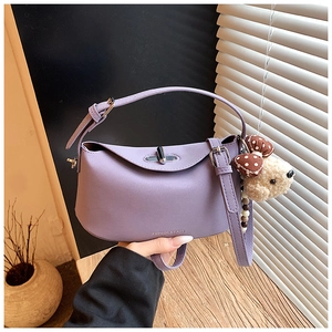 Detailed shot of purple crescent moon shoulder bag with cute teddy bear charm accessory