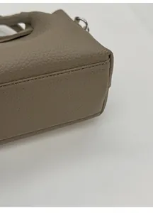 Détail de la base large et du cuir grainé litchi sur ce sac seau en cuir kaki