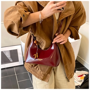 Bolso hobo de cuero burdeos con colgante de cuentas de madera y superficie pulida