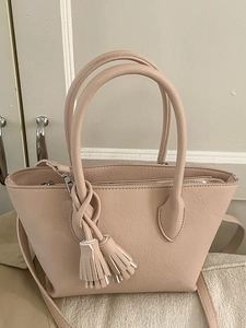 Sac seau rose minimaliste avec détail pompon et poignées rondes en cuir de lychee