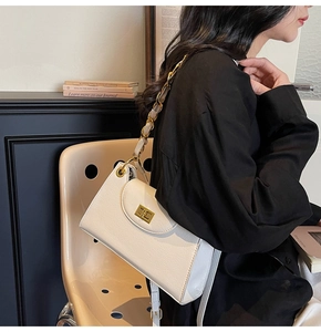 Detail of white vintage shoulder bag with gold chain strap and square metal buckle