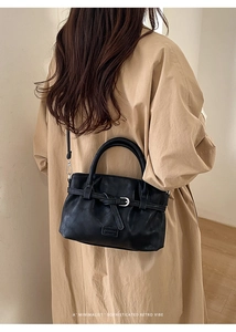 Detail of vintage black bucket bag showing leather texture and debossed fashion logo