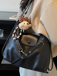 Minimalist black tote bag in matte faux leather with a cute puppy pendant and metal eyelets