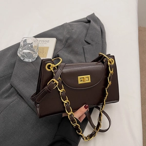 Detail of dark brown glossy leather bag with gold chain strap and vintage twist lock