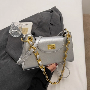 Detailed macro view of the silver metallic leather bag with gold chain and turn-lock closure
