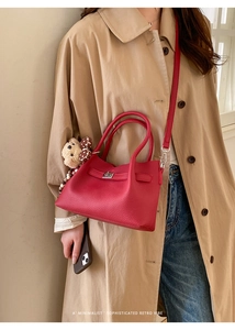Détail du sac seau en cuir grainé rouge avec fermoir rotatif et breloque petit ours