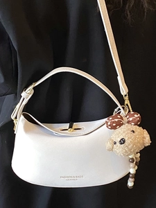 Chic white dumpling shaped shoulder bag with golden buckle and cute brown bear pendant